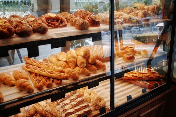 A glass bakery case of breads and pastries